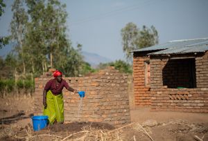 Ligineti Nayinayi a Cyclone Freddy Survivor is seen watering mud for making bricks at her village in Phalombe southern Malawi