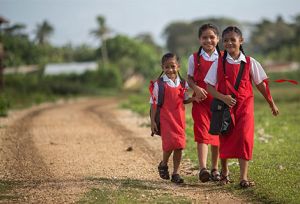 Girls walking to school on dirt road