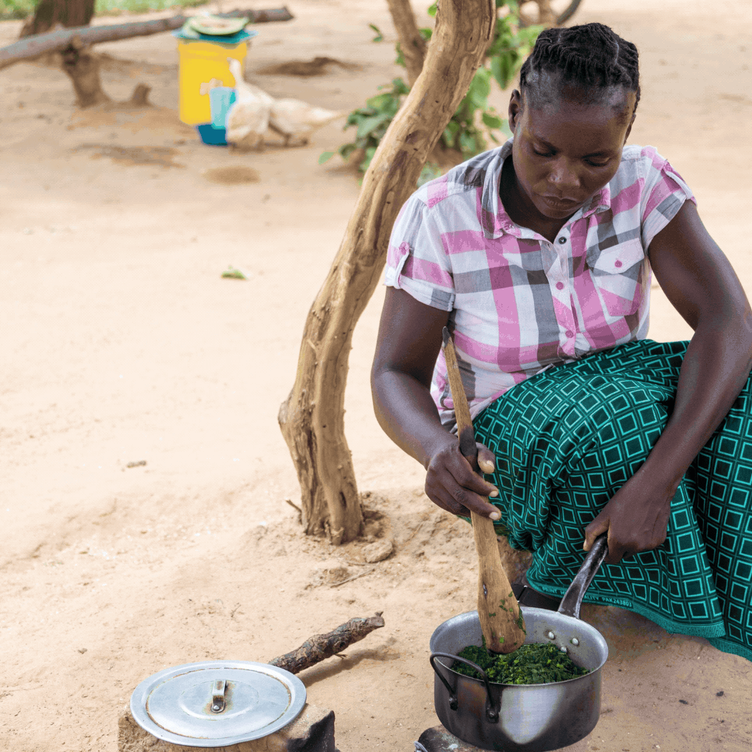 A lady in Zambia works and walks through fields
