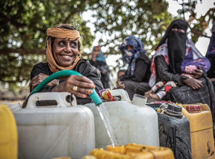 Suad Hassan collects and transports water in a jerry can.