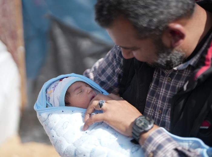 Feeda holding his newborn baby
