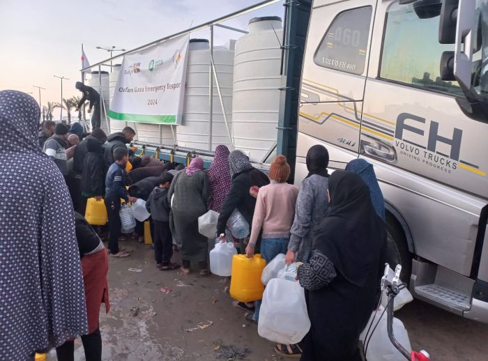 Internally displaced people in Rafah filling desalinated water provided by Oxfam in partnership with the Youth Empowerment Center.
