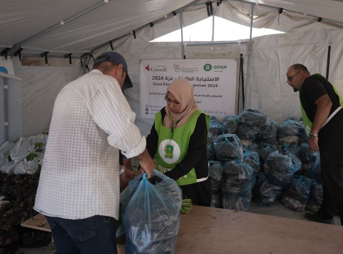 A man is receiving a vegetable basket distributed by Oxfam and partners in Deir Al Balah in the middle of Gaza.