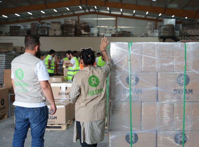Loading and packing a shipment of dry food parcels from Oxfam that was prepared for delivery.