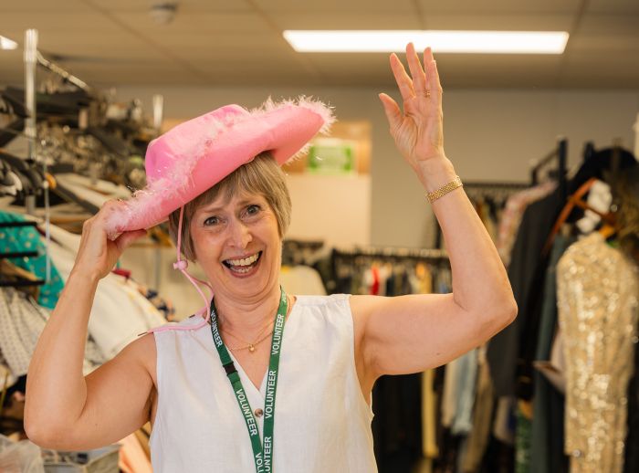 Barbara, a volunteer at Oxfam Holywood Superstore, having fun trying fancy hat.