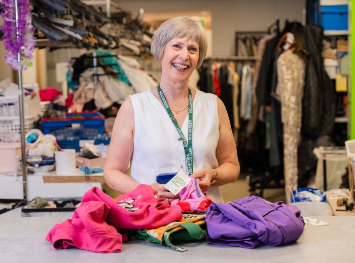 Barbara, a volunteer at Oxfam Holywood Superstore, sorting new donations.