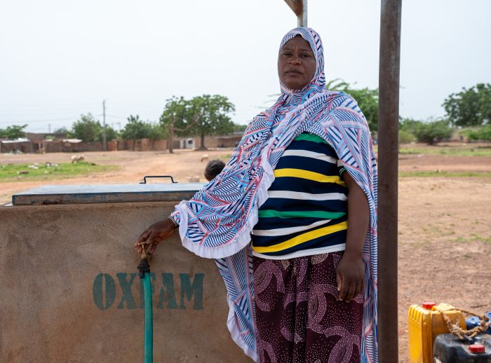 Adjaratou Sawadogo stands beside a water facility built by Oxfam in Boulsa, Burkina Faso.
