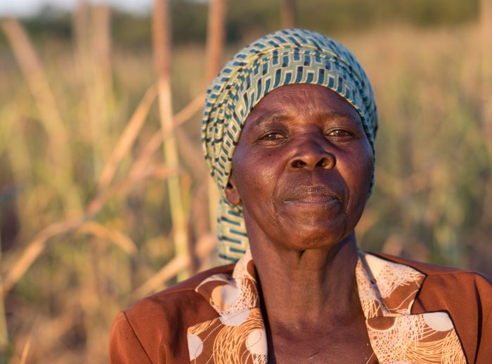 Fungai Nyikadzino, a farmer in Gutu, Zimbabwe, stands on her land affected by climate injustice and worsening droughts.