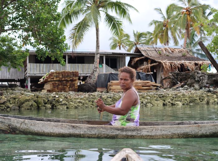 Joyce Kasiwai paddles a canoe near stilt houses in Aiarai village, West 'Are'are, Solomon Islands.