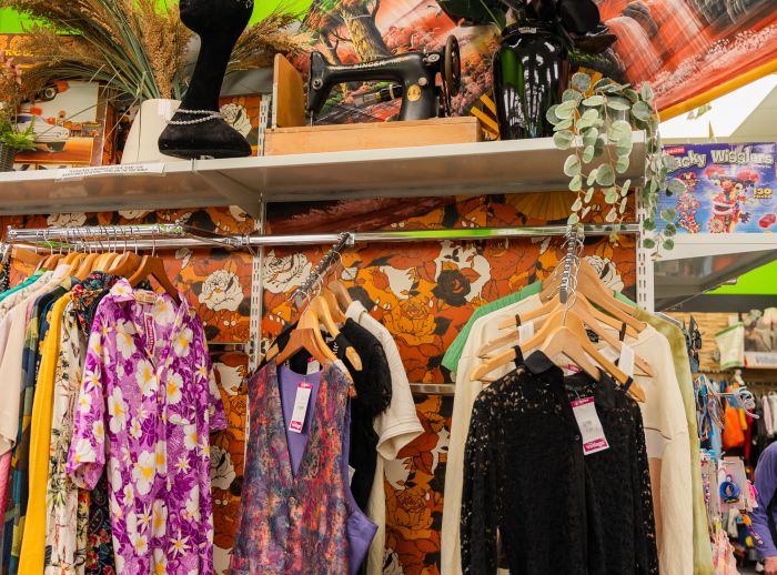 Shop floor with clothes hanging up on rails in many colours. 