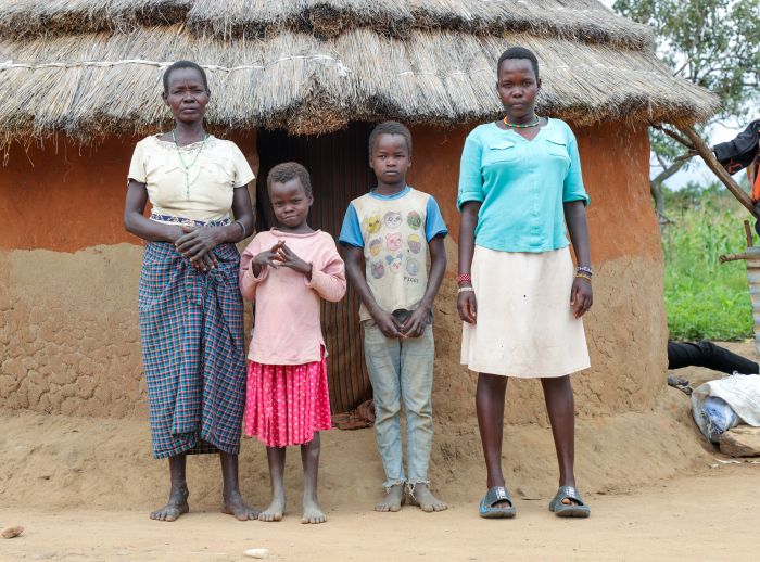 Mercy, her 2 siblings and her mum in front of their house