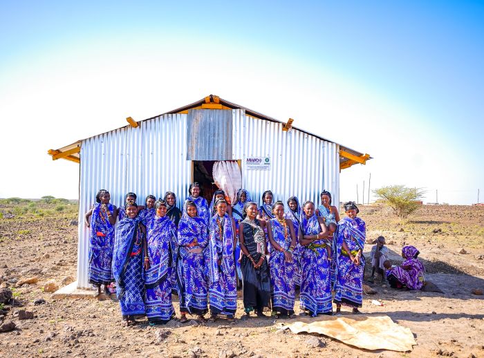 The women of Segei Machesa self help group stand in front of their newly constructed social hall.