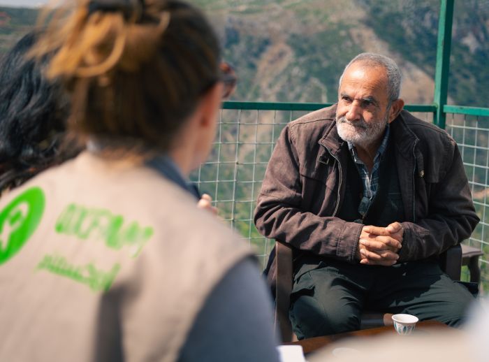 Oxfam staff having a conversation with Awad, Deir Mimas resident about the war and the water shortage