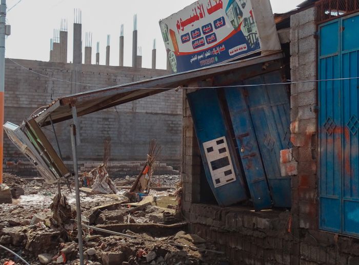 Photo showing parts of roads, wall fences, and workshops affected by floods.