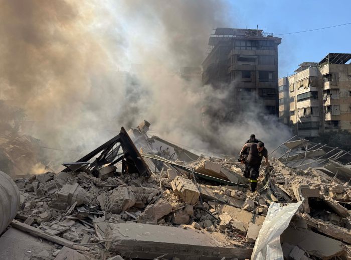 Rescue workers search through the rubble after Israel's overnight bombing of Beirut's southern suburbs