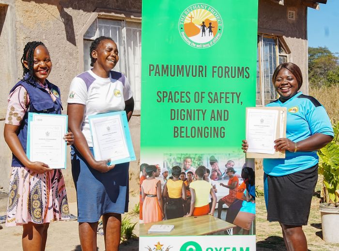 Young women from Zimbabwe holding their certificates