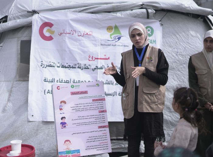An Oxfam partner health promoter leads a health promotion session attended by Niveen, a WASH program participant.