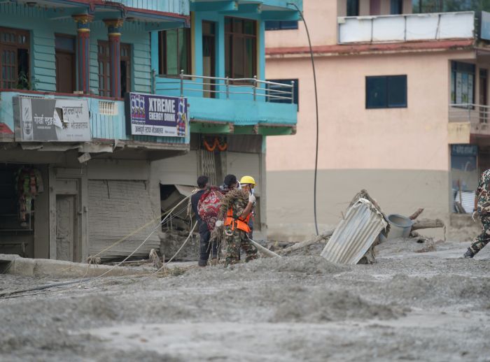 Two workers helping in flash floods in Nepal.