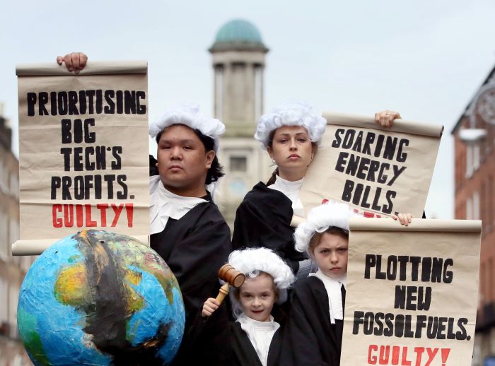 Four young people dressed as judges holding scrolls and a globe.