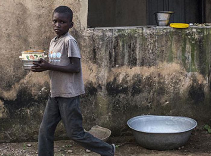 Disheveled boy carries plates