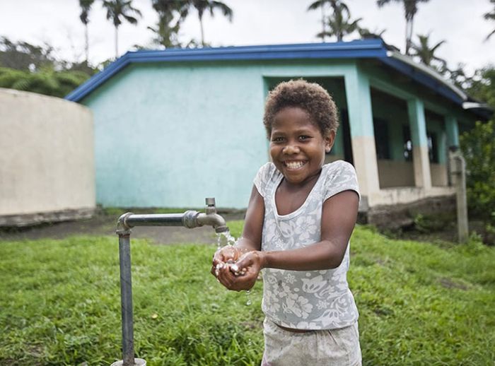 Child smiling washing hands