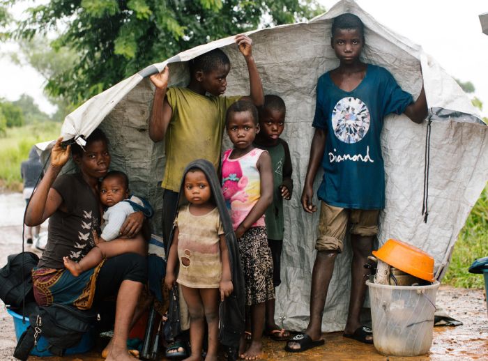 family taking refuge under temporary shelter