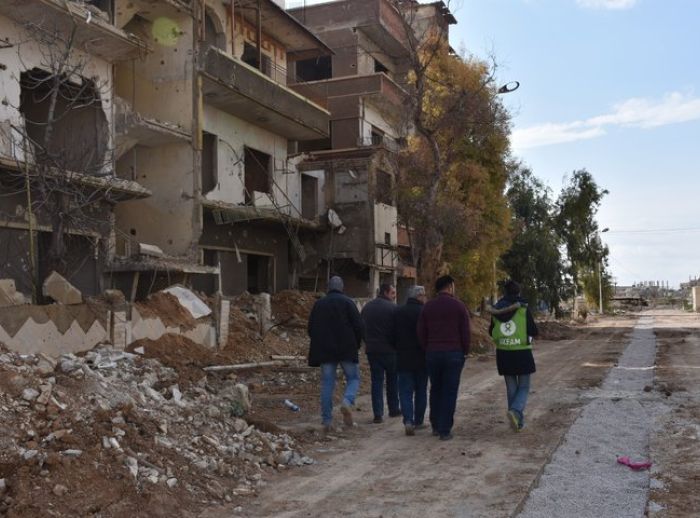 refugee man walks among Syria rubble