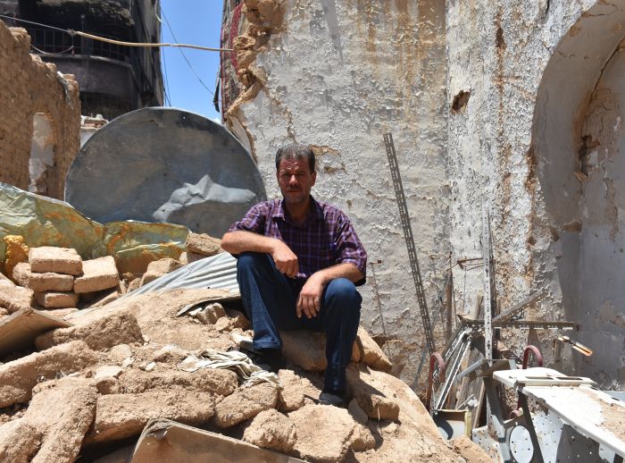man sits on his destroyed home