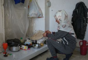 A displaced girl from Aleppo by the earthquake, makes a meal of boiled potatoes and bread