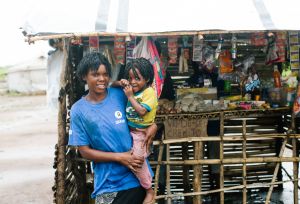 Sonia, and her child in front of her business