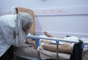Image of a doctor caring for a patient in an hospital bed.