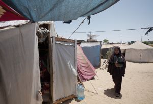 Duaa Abu Sabha holds water bottles while walking to her tent in the Al-Mawasi area in Khan Yunis Governorate.
