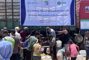 Group of displaced people trying to fill their jerrycans and buckets with water.