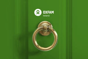 Door knob with Oxfam Ireland' logo above it. The door is green.
