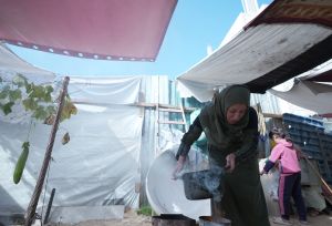 Woman cooking in manmade shelter on the West Bank.