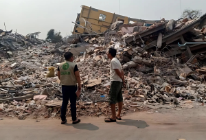 2 person looking at rubbles after the Myanmar earthquake. 