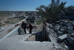 Suhad and her husband walking in the rubbles of their old house.
