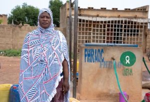Adjaratou Sawadogo stands beside a water facility built by Oxfam in Boulsa, Burkina Faso.
