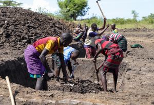 Farmers in Uganda working on a water pond