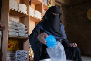 Oqba weighs out kilos of rice at her scales. She ensures each bag is properly weighed and arranged for sale