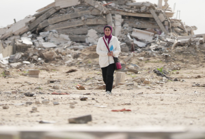 woman walking through rubble in Gaza