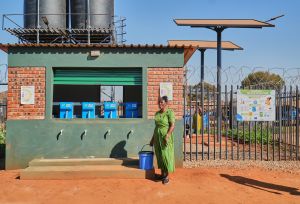 Tariro Zvirevo fetching clean water at an Oxfam water Kiosk in Kuwadzana.