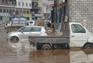 Two cars stopped in a street filled with water.