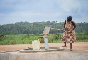 Adoko Juliana fetching water from the borehole at Bwiriza Zone, in Kyaka II Settlement.