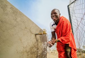 Ekai Adamson Samuel enjoying clean water at the water point in Moruese village.