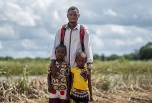 Somber man stands with his two children