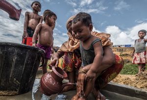 Habiba* washes her son at an Oxfam water pump. 