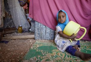 young child holding empty water jug