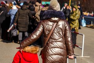 A Ukrainian mother walks with her daughter along the road from the Hungarian-Ukrainian border 