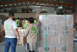 Loading and packing a shipment of dry food parcels from Oxfam that was prepared for delivery.